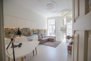 een keuken en een woonkamer met een tafel en een bank bij Porto D'Alma Santa Catarina Apartments in Porto
