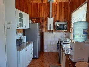 a kitchen with a refrigerator and a sink in it at Cabañas Agua Viva in Puerto Montt