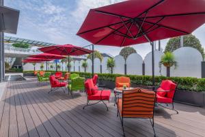 een patio met tafels en stoelen en rode parasols bij Jeurong Hotel Shanghai in Shanghai