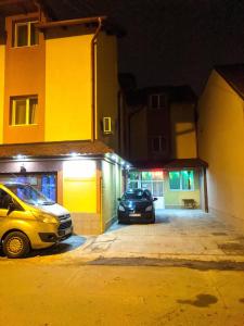 two cars parked in a parking lot at night at Pensiunea Vladut Timisoara in Timişoara