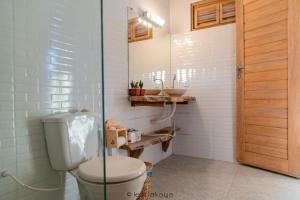ein Badezimmer mit Toilette und Glastür in der Unterkunft Casa Éolica in Barra Grande