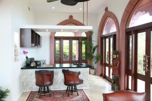 a kitchen with a bar with leather chairs at Jodha Bai Retreat in Terranora