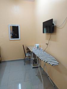 ein Esszimmer mit einem Tisch und einem TV in der Unterkunft Homestay Teratak Umi Klang in Klang