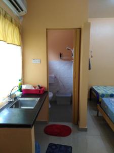 a bathroom with a sink and a bathroom with a toilet at Homestay Teratak Umi Klang in Klang