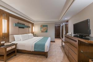 a hotel room with a bed and a flat screen tv at Henann Regency Resort and Spa in Boracay