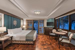 a hotel room with a bed and a table and chairs at Henann Regency Resort and Spa in Boracay