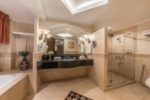 a bathroom with a tub and a sink and a shower at Henann Regency Resort and Spa in Boracay