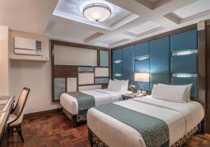 a hotel room with two beds and a table at Henann Regency Resort and Spa in Boracay