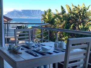 a dining room table with a view of the ocean at Gull on the Bay Boutique Guest House in Bloubergstrand