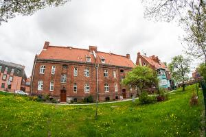 a large brick building in a field of green grass at Apartament Ołowianka- Danzig in Gdańsk