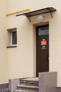 eine schwarze Tür an der Seite eines Gebäudes in der Unterkunft Sweet Apartments in Šiauliai