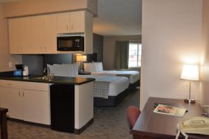 um grande quarto de hotel com uma cama e uma cozinha em FairBridge Inn & Suites DuPont em DuPont