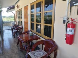 a room with a wooden table and a fire extinguisher at Yotin Guest House in Trat