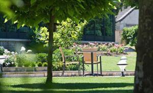 um parque com um banco, uma mesa e flores em Chateau Du Mont Joly em Sampans