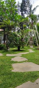 a park with stepping stones in the grass with trees at Tangkas House in Tampaksiring