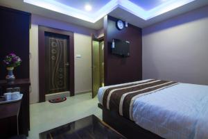a bedroom with a bed and a tv on the wall at CITY VIEW in Port Blair