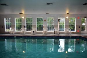 a swimming pool with chairs and a swimming pool at FairBridge Inn & Suites DuPont in DuPont