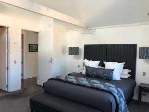 a bedroom with a large bed with a black headboard at Luxurious Loft Apartments in the heart of Ahuriri in Napier