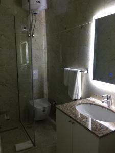 uma casa de banho com um lavatório, um WC e um chuveiro em Ramel Hotel em Tirana