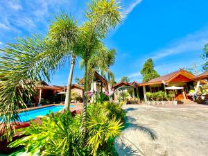 a resort with a pool and palm trees at Khum Lanna Boutique Hotel in Si Sa Ket