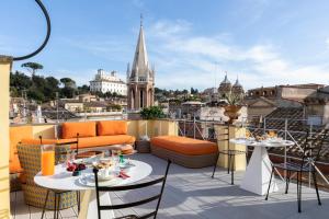 a balcony with tables and chairs and a view of a city at Poēsis Experience Hotel in Rome