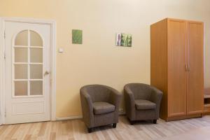 two chairs in a room with a door and a cabinet at Pigi nakvyne in Šiauliai