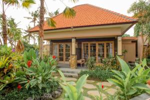 Auma Villa by Prasi في أوبود: منزل صغير بسقف برتقالي