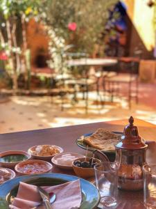 une table en bois avec des assiettes de nourriture dans l'établissement Dar M'hamid, à M'Hamid El Ghizlane