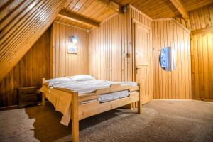a bedroom with a bed in a wooden room at Chata pod Bukiem 1 in Kościelisko