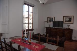 ein Esszimmer mit einem Tisch und einem TV in der Unterkunft Medici chapels apartment, near the Duomo!! in Florenz