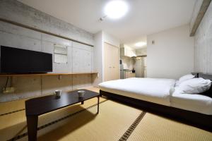 a bedroom with a bed and a tv on a wall at Hotel Resort Inn Ishigakijima in Ishigaki Island