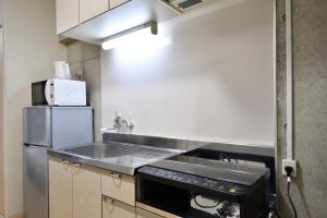 a kitchen with a sink and a microwave at Hotel Resort Inn Ishigakijima in Ishigaki Island