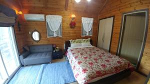sypialnia z łóżkiem i niebieską kanapą w obiekcie Sisilli Pension w mieście Pjongczang