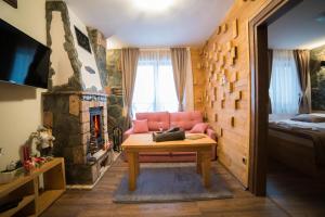 a living room with a pink couch and a fireplace at Drugarska priča in Jahorina