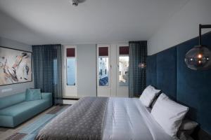 a bedroom with a large bed and a couch at Hotel Derlon in Maastricht