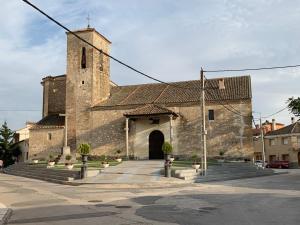 una antigua iglesia de piedra con una gran torre en Casa en Martín Miguel a 15 Minutos de Segovia, en Martín Miguel