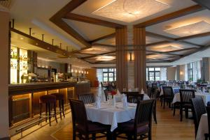 a restaurant with white tables and chairs and a bar at Lion Bansko Hotel in Bansko
