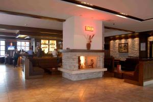 a lobby with a fireplace in a restaurant at Lion Bansko Hotel in Bansko +56 photos