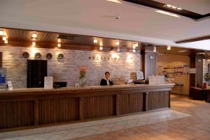 a woman standing at a bar in a restaurant at Lion Bansko Hotel in Bansko +55 photos