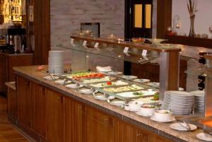 a buffet line with plates and bowls of food at Lion Bansko Hotel in Bansko