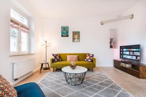 a living room with a yellow couch and a tv at #1 AUGSBURG Altstadtjuwel in Augsburg
