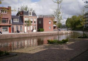 een rivier in een stad met huizen en gebouwen bij B&B de Ferver in Leeuwarden