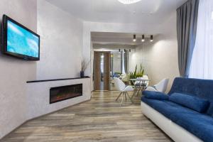a living room with a blue couch and a fireplace at New luxury Apartment in the Center on Konstitution Square in Kharkiv