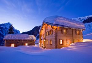 un grande edificio in legno con la neve sopra di Unterboden 5 a Schröcken