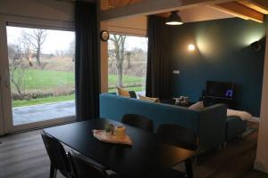 a living room with a blue couch and a table at Ruim appartement in prachtige fiets-wandelomgeving in Abcoude