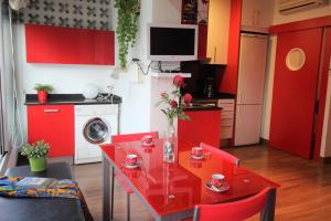 ロザスにあるGlobal Immo 1035 Sol Levanteの赤いキャビネット、赤いテーブルと赤い椅子付きのキッチン