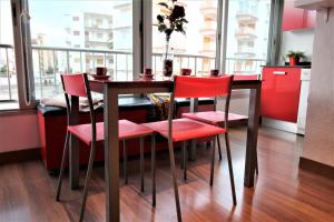 ロザスにあるGlobal Immo 1035 Sol Levanteのダイニングルーム(テーブル、赤い椅子付)