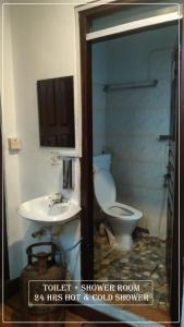 Planet Nomad Hostel في كاتماندو: حمام به مرحاض أبيض ومغسلة