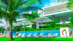 - une piscine avec des chaises et des parasols à côté d'un bâtiment dans l'établissement Myra Luxury Seafront Apartment, à Cap Malheureux