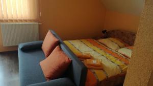 um quarto com uma cama e um sofá em Penzión Ranč Šenkvice em Veľké Čaníkovce